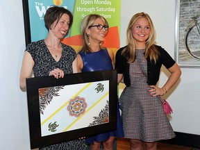 Tamara Kowalska (left) presents a gift to Stephanie and Samantha Zekelman (right) during a press conference to announce the Windsor Youth Centre had reached their fund-raising goal at the Twisted Apron in Windsor on Thursday, May 14, 2015. The WYC raise $640,000. Surpassing their goal of $500,000. The money allows them to purchase a new larger building.             (TYLER BROWNBRIDGE/The Windsor Star)
