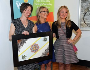 Tamara Kowalska (left) presents a gift to Stephanie and Samantha Zekelman (right) during a press conference to announce the Windsor Youth Centre had reached their fund-raising goal at the Twisted Apron in Windsor on Thursday, May 14, 2015. The WYC raise $640,000. Surpassing their goal of $500,000. The money allows them to purchase a new larger building.             (TYLER BROWNBRIDGE/The Windsor Star)