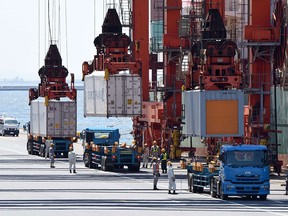 Giant cranes unload containers from a cargo ship at a pier in Tokyo on May 13, 2015. Japanese know-how, companies and investments are a cornerstone of prosperity in almost every corner of Asia, including China, Vietnam and Burma. (TORU YAMANAKA / AFP / Getty Images)