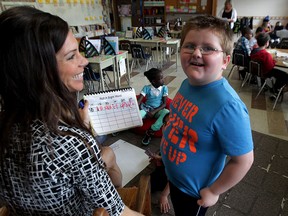 Immaculate Conception Catholic Elementary school student Noah Armstrong, right, wearing his Never Ever Give Up shirt,  shows teacher Cassia Pulleyblank his work during class Wednesday June 4, 2015. (NICK BRANCACCIO/The Windsor Star)