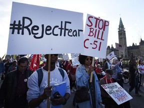 People rally against Bill C-51, the government's anti-terror legislation, as they pass Parliament Hill during a International Workers' Day protest against austerity measures in Ottawa on Friday, May 1, 2015. THE CANADIAN PRESS/Justin Tang