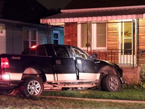 Emergency personnel work to free a man from a pickup truck he crashed into the front porch of a home on the 1600 block of Hickory Rd., in July 2013. The driver was allegedly trying to run down his common-law wife. On Monday, Sonny St. Martin, 30, pleaded guilty in Superior Court to the attack on Jessica Rushlow. (REBECCA WRIGHT/The Windsor Star)