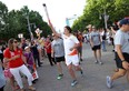 Boxer Mary Spencer carries the Pan Am Games torch as it makes its way into Windsor on Tuesday, June 16, 2015. (TYLER BROWNBRIDGE/The Windsor Star)