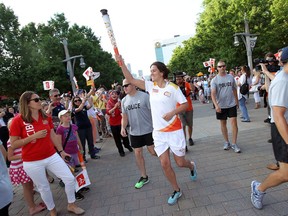 Boxer Mary Spencer carries the Pan Am Games torch as it makes its way into Windsor on Tuesday, June 16, 2015. (TYLER BROWNBRIDGE/The Windsor Star)