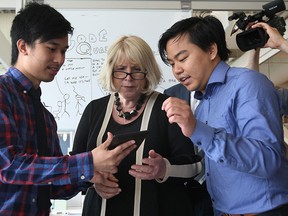 Deputy Premier Deb Matthews, centre, and University of Windsor alumni Scott Nguyen, 24, and Jimmy Truong, 24, discuss an app they've created during a tour University of Windsor's business incubator EPICentre (Entrepreneurship, Practice and Innovation) June 8, 2015. (NICK BRANCACCIO/The Windsor Star).