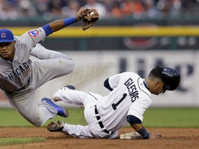 Chicago Cubs second baseman Addison Russell tumbles next to Detroit Tigers' Jose Iglesias after tagging Iglesias out on an attempted steal during the fifth inning of a baseball game, Tuesday, June 9, 2015, in Detroit. (AP Photo/Carlos Osorio)