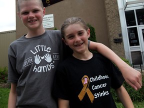 Friends since kindergarten, Andrew Gatto, 12, left, and Ezra Weatherman, 11, share a few moments at St. Anne's French Immersion school on Monmouth Road during their annual fundraising event to support the Carl & Gloria Morgan Scholarship for Cancer Research at the University of Windsor June 11, 2015. Gatto has recovered following treatment for alveolar rhabdomyosarcoma, a cancer of muscle tissue.  Showing the true meaning of friendship, Weatherman has stayed close and visited Gatto while in hospital.  Weatherman donated his long hair and spoke about his friendship during an enthusiastic assembly at St. Anne's where several students had their hair cut and fundraising totals were announced. (NICK BRANCACCIO/The Windsor Star).