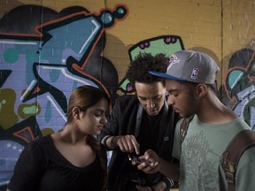 Photographer Taha Muharuma, centre, from the #CaptureTheStreets Project works with George Bouck, right, and Yasmin Jilani in Toronto on Friday, May 29, 2015. The #CaptureTheStreets Project is a collaboration between community organizations and photographers to provide a platform for homeless and at-risk youth to share their stories through art. THE CANADIAN PRESS/Chris Young