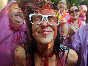 A man pours red wine on a girl's head during the"Batalla del Vino" (Battle of Wine) in Haro, on June 29, 2015. Every year thousands of locals and tourists climb a mountain in the northern Spanish province of La Rioja to celebrate St. Peter's day covering each other in red wine while tanker trucks filled with wine distribute the alcoholic beverage to water pistols, back mounted spraying devices, buckets which are randomly poured on heads and into any other available container. More than nine thousand people threw around 130,000 litres of wine during this year's Haro Wine Festival, according to local media.