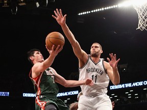 Ersan Ilyasova, left, of the Milwaukee Bucks scores two in the first half as Brook Lopez of the Brooklyn Nets defends at the Barclays Center. (Photo by Bruce Bennett/Getty Images)