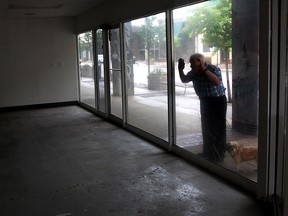 Wallace Patrick peers through a cloudy window of 406 Pelissier Street, a street-level retail spaces located within Pelissier Street Parking Garage Monday June 15, 2015. Patrick walks the area almost every day.  "This one has been empty a year or so," said Patrick, looking at 406.  "That other one, I can't tell you, it has been empty for so long." (NICK BRANCACCIO/The Windsor Star)