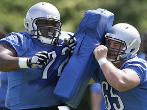 Detroit Lions center Taylor Boggs (65) runs a drill with guard Laken Tomlinson, left, runs a drill uring NFL football minicamp, Tuesday, June 16, 2015, in Allen Park, Mich. (AP Photo/Carlos Osorio)