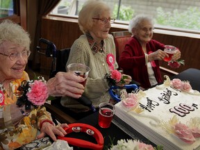 Birthday girls Arylene Girard, 100, left, Sunny Gasparet, 103, and Mary Bishop, 102, right, pose with a large birthday cake at Lifetimes Retirement Residence Monday.  The centenarians enjoyed music supplied by singer Beverly Bechard, toasted with cranberry juice and chatted with friends and family.  (NICK BRANCACCIO/The Windsor Star).