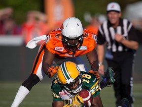 Windsor's Chris Rwabukamba, top, defends against Edmonton's Cory Watson during the first half of a pre-season CFL football game Friday in Vancouver. (THE CANADIAN PRESS/Darryl Dyck)