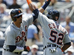 Detroit Tigers on deck-batter Yoenis Cespedes (52) greets Tigers designated hitter Victor Martinez (41) after Martinez hit a first-inning, two-run home run in a baseball game against the New York Yankees at Yankee Stadium in New York, Sunday, June 21, 2015.  (AP Photo/Kathy Willens)
