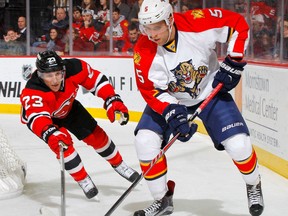 Aaron Ekblad #5 of the Florida Panthers plays the puck behind the net in the second period against Mike Cammalleri #23 of the New Jersey Devils at the Prudential Center on January 31, 2015 in Newark, New Jersey.  (Photo by Jim McIsaac/Getty Images)