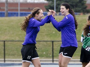 WINDSOR, Ont. (07/04/2015) Assumption girlsÕ soccer team member Victoria Cope (left) high-fives her teammate, Emma Rothera, after scoring a goal at the beginning of the second half of their game against Herman, Tuesday April 7. Herman went on to defeat Assumption 3-2. GABRIELLE SMITH/Special to The Windsor Star