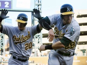 Oakland Athletics' Mark Canha (20) and Eric Sogard (28) score off of teammate Billy Burns' 3-run triple off Detroit Tigers starting pitcher Anibal Sanchez during the second inning of a baseball game, Wednesday, June 3, 2015, in Detroit. (AP Photo/Carlos Osorio)