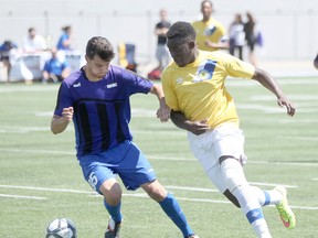 Bishop F. Marrocco's Dante Orfao, left, battles for the ball with St. Joseph's Clive Osenda during the OFSAA boy's AAA Soccer final at Alumni Field, Saturday, June 6, 2015.  (DAX MELMER/The Windsor Star)