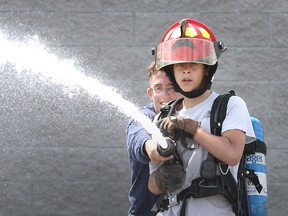 John Campbell grade 8 student Jordan Spina takes part in a Pre-Service Firefighter Education & Training drill during the Amazing Skills Challege event for grade 8 students at St. Clair College in Windsor on June 9, 2015.   (JASON KRYK/The Windsor Star)