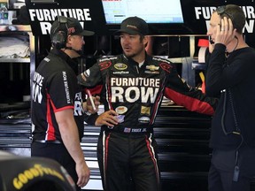 LONG POND, PA - JUNE 05:  Martin Truex Jr., driver of the #78 Furniture Row/Visser Precision Chevrolet, center, speaks with crew chief Cole Pearn, right, and a crew member in the garage area during practice for the NASCAR Sprint Cup Series Axalta "We Paint Winners" 400 at Pocono Raceway on June 5, 2015 in Long Pond, Pennsylvania.