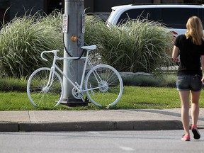 Family of the cyclist killed approach a ghost bike that was place as a tribute in Windsor on Monday, June 29, 2015. Cyclists took part in a ride that was planned to bring awareness and promote safe cycling.                    (TYLER BROWNBRIDGE/The Windsor Star)