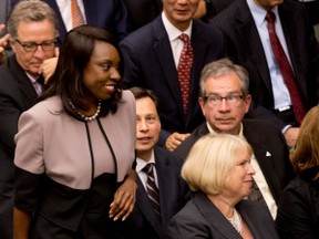 Associate Minister of Finance (Ontario Retirement Pension Plan) Mitzie Hunter, left, walks to be officially sworn in at Queen's Park in Toronto on Tuesday, June 24, 2014. THE CANADIAN PRESS/Nathan Denette