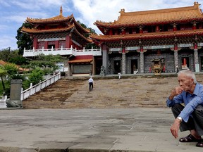An elderly man crouches outside of a temple in Taiwan. (DOUG SCHMIDT/The Windsor Star)