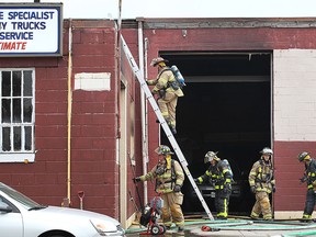 Windsor firefighters are shown at the scene of a fire at N&G Auto Body in the 1300 block of Crawford Ave. on Tuesday, June 30, 2015, in Windsor, ON. The fire which started in a car inside the garage was quickly put out by firefighters. (DAN JANISSE/The Windsor Star)