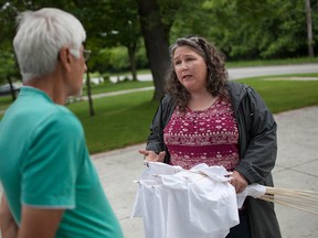Debby Grant, chair of the Windsor Essex Right to Know, speaks with Remington Park resident, Jean Merheje, about the group's white flag campaign, Saturday, June 13, 2015. (DAX MELMER/The Windsor Star)