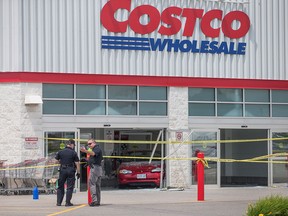 Police investigate after a car backed through the entrance of Costco in London, Ont., on Friday, July 25, 2014. Six people were injured, including a child who was in critical condition, after a car crashed through the front doors of a busy Costco store. THE CANADIAN PRESS/ Geoff Robins