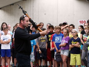 Const. Larry Hartley demonstrates several firearms during VIP Day at the Tilston Armoury in Windsor on Wednesday, June 9, 2015. Grade six students were invited to participate in the event. Values, Influence and Peers is an education program delivered to students which features members of the K-9 unit, ESU, emergency disposal and firearms unit.               (TYLER BROWNBRIDGE/The Windsor Star)