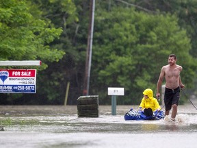 Andrew Roberts pulls Rebecca Wright in a dingy down a flooded Coterie Park outside Wheatley after 3-4 metre high waves and rain flooded the street, Saturday, June 27, 2015.  (DAX MELMER/The Windsor Star)
