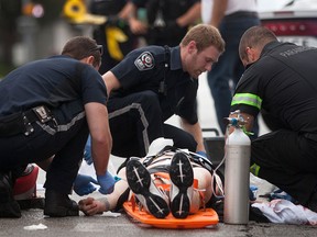 EMS Paramedics tend to a young man with apparent stab wounds on Wyandotte St. W. at Dougall Ave., Sunday, June 14, 2015.  (DAX MELMER/The Windsor Star)