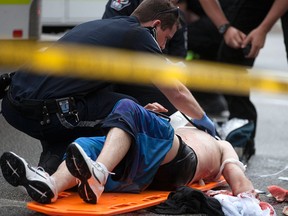 EMS Paramedics tend to a young man with apparent stab wounds on Wyandotte St. W. at Dougall Ave., Sunday, June 14, 2015.  (DAX MELMER/The Windsor Star)
