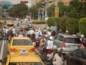 Mopeds are everywhere you look in Taiwan. In a country of 23 million, there are an estimated 20 million mopeds crowded onto its streets. At lighted traffic intersections, the front areas are reserved for the small motorbikes, and their drivers love to squeeze in between stopped vehicles on red lights in order to get a head start when the light turns green. (Doug Schmidt/The Windsor Star)