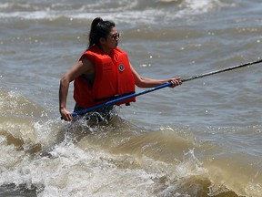 Jennifer Lee takes a water sample at Holiday Beach in Essex County on Wednesday, June 9, 2015. The local health unit has begun their weekly testing of the water at local beaches.               (TYLER BROWNBRIDGE/The Windsor Star)