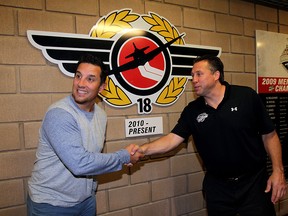 Bob Boughner, left, is following his dream and has taken a coaching position in the NHL,  July 03, 2015. Warren Rychel offers a symbolic handshake during a media conference at WFCU Centre.  Boughner will remain team president.  (NICK BRANCACCIO/The Windsor Star).