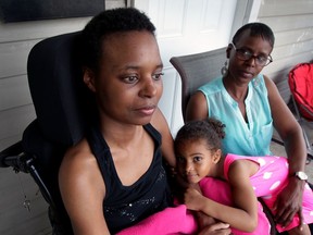 Aisha Washington, left, sits on her front porch with her mother, Gail Washington, and her daughter, Jahzera, 5, on July 9, 2015. (NICK BRANCACCIO/The Windsor Star)