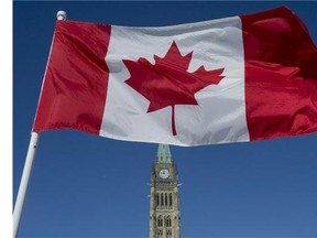 The Canadian Flag flies over the Peace Tower on Parliament Hill on the 50th anniversary of the Canadian Flag in Ottawa on Sunday, Feb. 15, 2015.
(Justin Tang/Postmedia News)