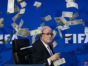 FIFA president Sepp Blatter looks on with fake dollars note flying around him thrown by a protester during a press conference at the football's world body headquarter's on July 20, 2015 in Zurich. FIFA said today that a special election will be held on February 26 to replace president Sepp Blatter.   AFP PHOTO / FABRICE COFFRINIFABRICE COFFRINI/AFP/Getty Images