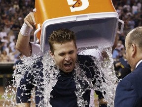 Minnesota Twins’ Brian Dozier gets doused with water during an interview following his walk-off, three-run home run off Detroit Tigers pitcher Joakim Soria during the ninth inning of a baseball game, Friday, July 10, 2015, in Minneapolis. The Twins won 8-6. (AP Photo/Jim Mone)