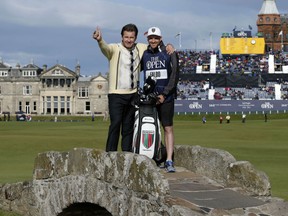 England's Nick Faldo (L) poses with his son and caddie Matthew, on the Swilcan Bridge to mark his final round in a British Open at St Andrews, wearing the same jumper he wore when winning at Muirfield in 1987, during his second round on day two of the 2015 British Open Golf Championship on The Old Course at St Andrews in Scotland, on July 17, 2015. AFP PHOTO / ADRIAN DENNISADRIAN DENNIS/AFP/Getty Images