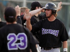 Tecumseh Thunder Juniors Ross Barker, right, is congratulated by teammates including Noah Pickering, left, and Jeff Watkin, behind, after scoring during a four-run inning against Tecumseh Seniors at Lacasse Park Friday July 17, 2015. (NICK BRANCACCIO/The Windsor Star)