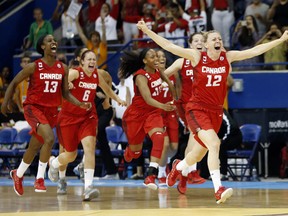 Canada athletes run onto the court after beating the United States 81-73 in the women's basketball gold medal game at the Pan Am Games, Monday, July 20, 2015, in Toronto. (AP Photo/Julio Cortez)