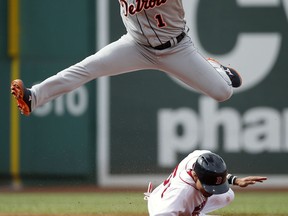 Detroit Tigers' Jose Iglesias (1) jumps after getting the forced out on Mookie Betts, bottom, and turning the double play on Brock Holt during the first inning of a baseball game in Boston, Saturday, July 25, 2015. (AP Photo/Michael Dwyer)