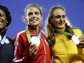 Women's 800 meter gold medal winner Melissa Bishop, center, of Canada, poses with silver medal winner Alysia Montano, left, of the United States, and bronze medal winner Flavia De Lima, right, of Brazil, during the medal ceremony at the Pan Am Games Wednesday, July 22, 2015, in Toronto. (AP Photo/Mark Humphrey)