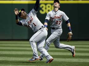 Detroit Tigers' shortstop Jose Iglesias (1) is backed up by Tigers' third baseman Andrew Romine (27) as Iglesias struggles to catch a pop-out hit by Seattle Mariners' Kyle Seager in the fourth inning of a baseball game, Wednesday, July 8, 2015, in Seattle. Iglesias made the catch for the out. (AP Photo/Ted S. Warren)