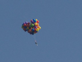 A Calgary man got more than he bargained for when he flew over the city in a lawn chair attached to helium balloons and then had to parachute to safety.Police have charged the man with mischief and say more charges could be on the way.  (THE CANADIAN PRESS/Tom Warne)