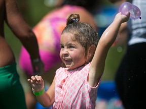 Coco Leddy, 2, throws a water balloon during the Spotted in Windsor Community Water Balloon Fight at Lanspeary Park, Sunday, July 26, 2015.  (DAX MELMER/The Windsor Star)